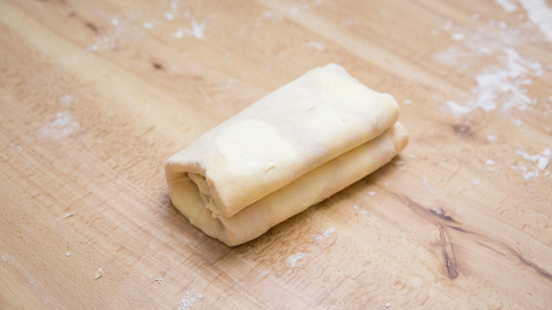 folded dough on wooden table