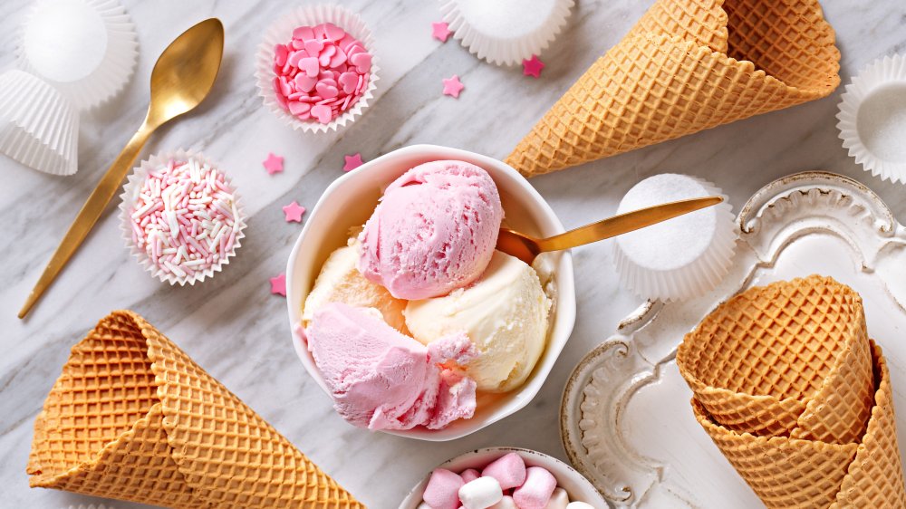 bowl of ice cream with toppings around it in smaller bowls