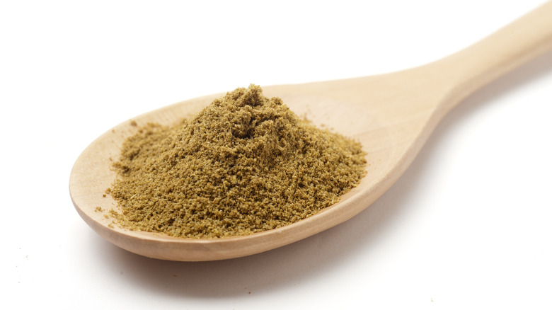 Ground cumin on a wooden kitchen spoon