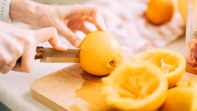 A woman cutting some oranges