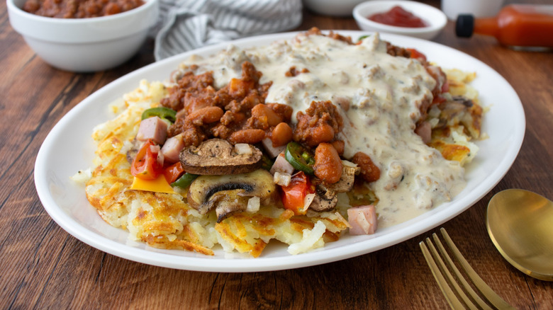 Copycat Waffle House All-the-Way Hash Browns on a serving platter next to utensils