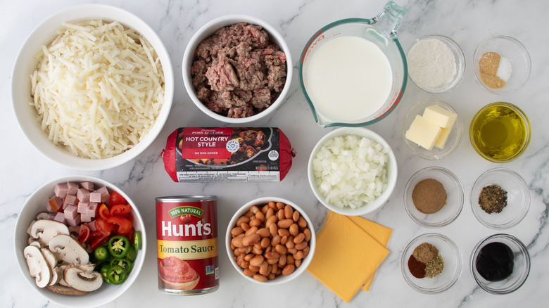 Diced veggies, diced ham, ground meat, pinto beans, and other Copycat Waffle House All-the-Way Hash Browns ingredients laid out