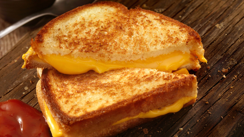 Grilled cheese sandwich on a board with ketchup