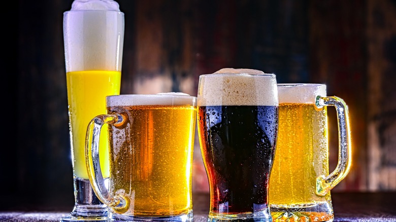 Four different types of beer and malt liquor in assorted glasses.