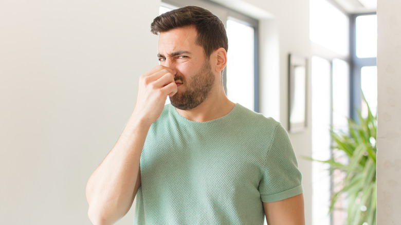 Man holding his nose like something smells