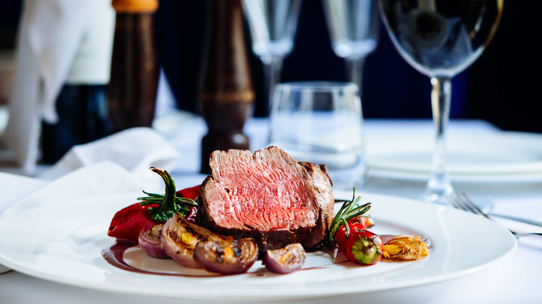 medium rare steak on plate with wine