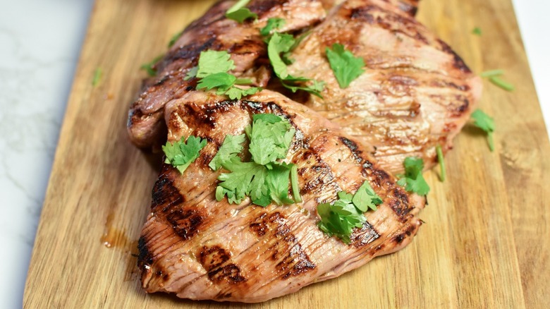 grilled pork steaks on board with cilantro