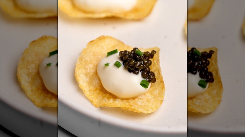 Potato chip topped with crème fraîche, caviar, and chives.