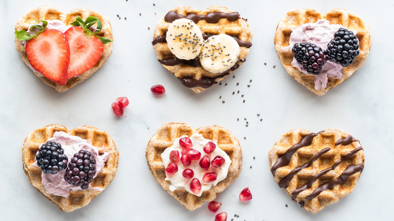 Heart-shaped waffles with various toppings