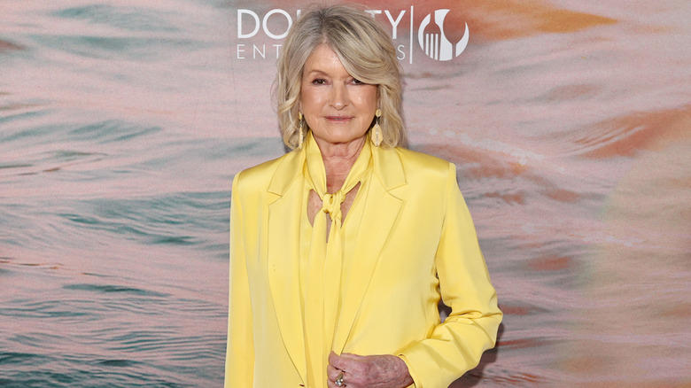 Martha Stewart posing at an event in a bright yellow suit and top
