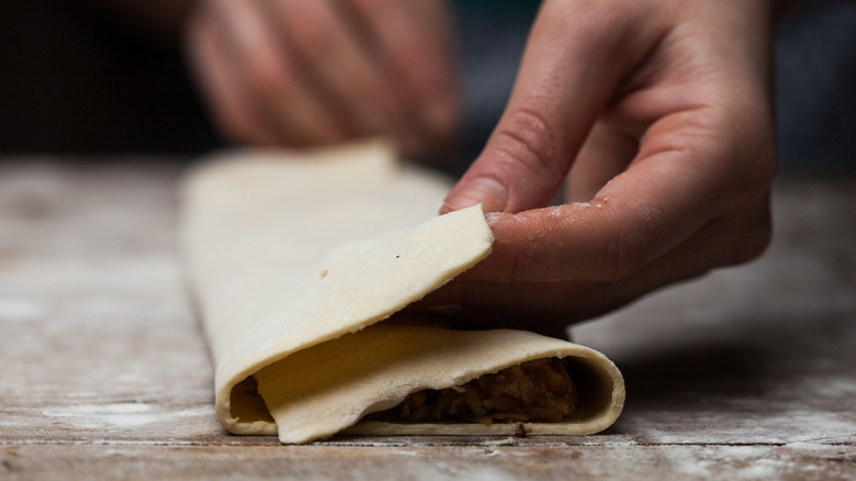 Close up, hands assembling pastry into a letter fold