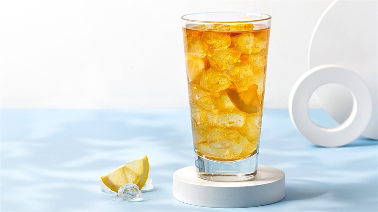 iced tea in glass on white coaster with lemon wedge