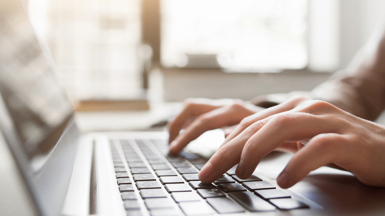 hands typing on laptop