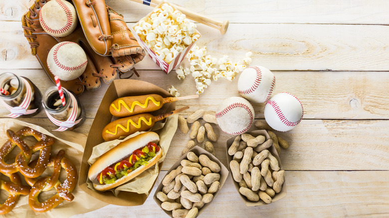 Pretzels, peanuts, hot dog, corn dogs, baseballs and gloves