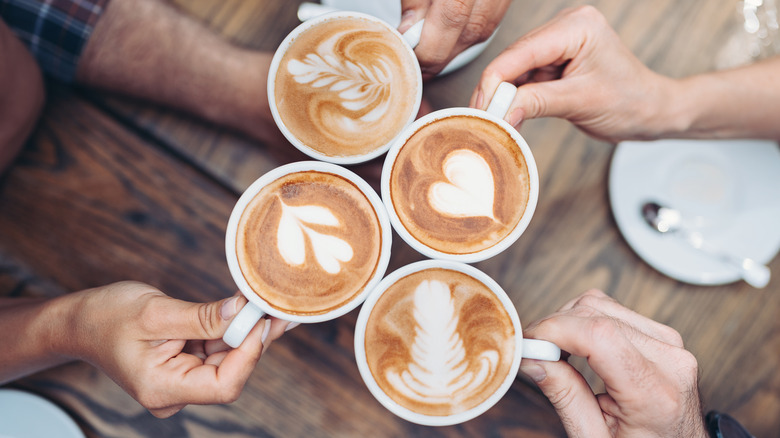 hands holding coffee cups