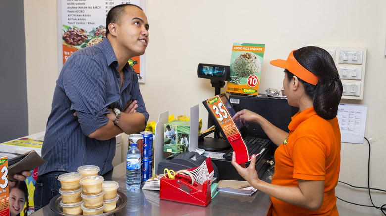 Person ordering food at a fast food restaurant.