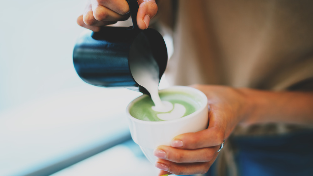Pouring matcha tea into a cup