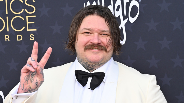 Matty Matheson smiling and flashing a peace sign on the red carpet