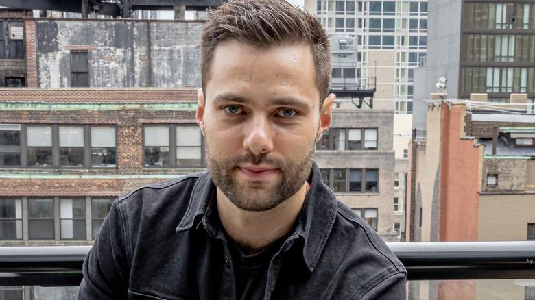 Max Greb staring into camera on balcony