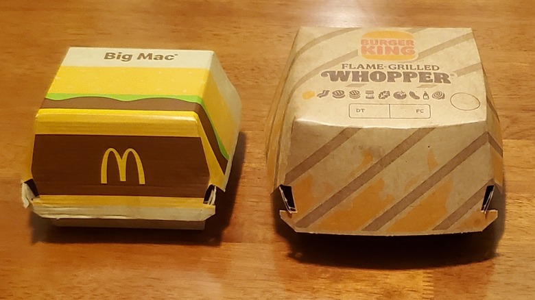 McDonald's Big Mac and Burger King Whopper takeout boxes side by side on table