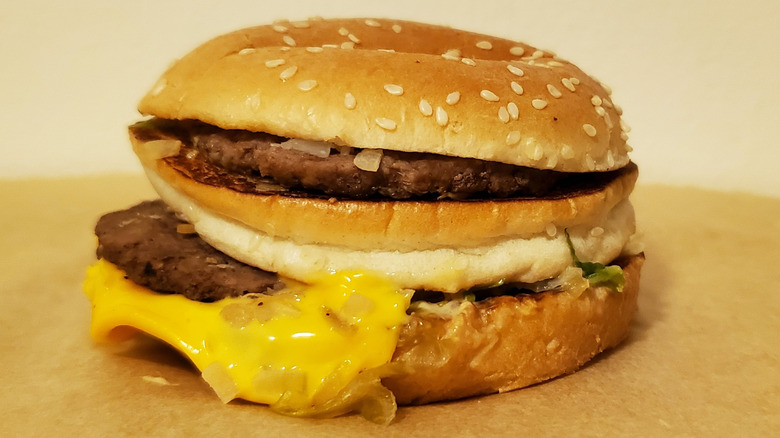 Close up of a McDonald's Big Mac with two patties, cheese, and diced onions on sesame seed bun