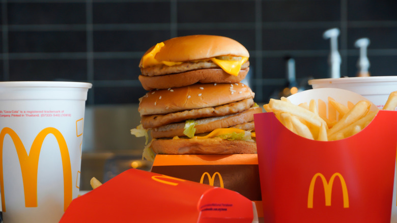 Stack of three McDonald's sandwiches surrounded by fries and a drink.