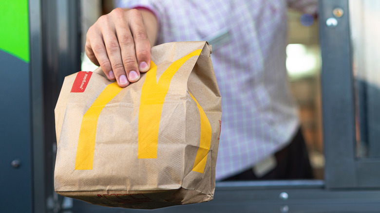 McDonald's employee holding bag of food