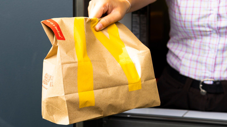 McDonald's bag extending from drive-thru window