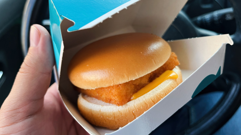 Person holding takeout box with McDonald's Filet-O-Fish sandwich