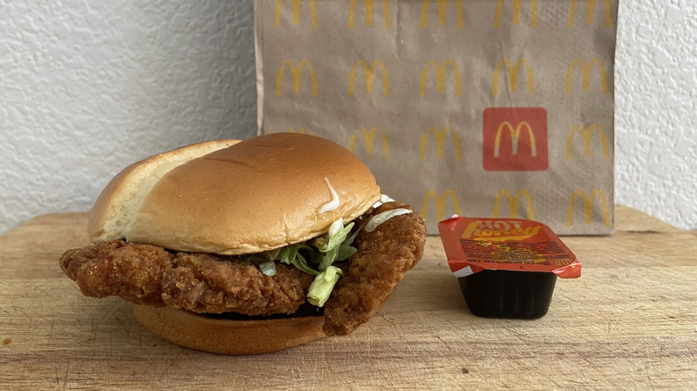 Hot Honey McCrispy on a cutting board with sauce cup and a McDonald's bag
