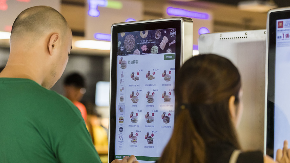 People ordering food at McDonald's screen