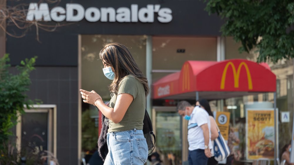 person checking phone in front of McDonald's