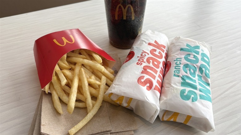 Two McDonald's Snack Wraps with fries and a cola