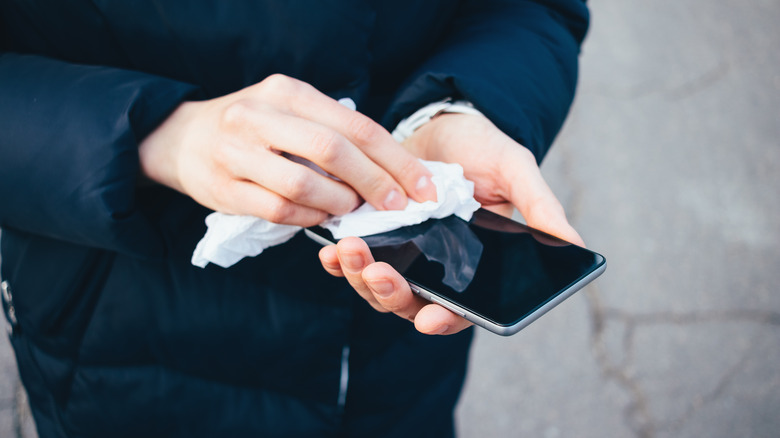 person cleaning their phone