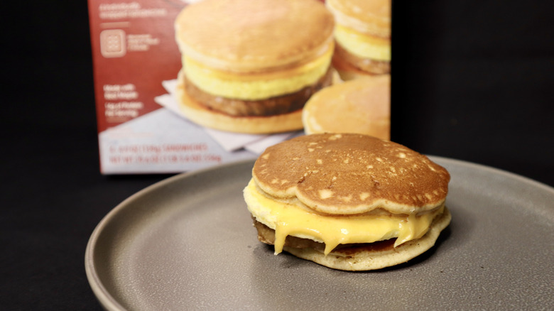 breakfast sandwich on plate in front of box