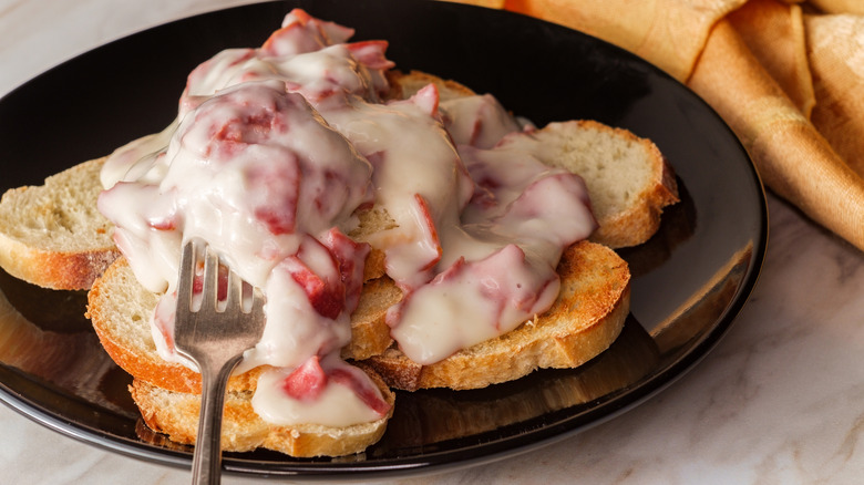 Close-up of chipped beef on toast on a black plate