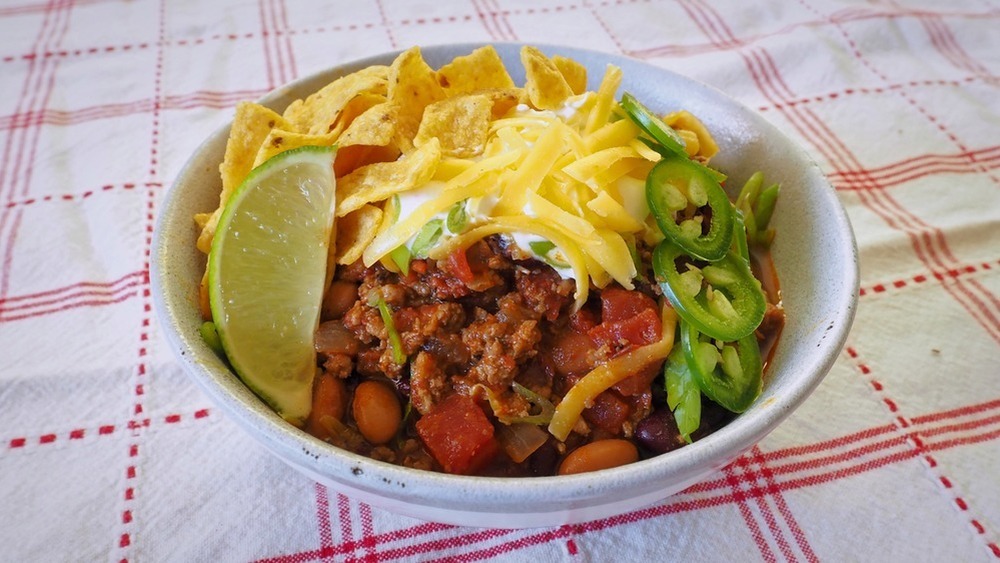 5-ingrediens chili i hvid skål med limebåd og jalapeno-skiver