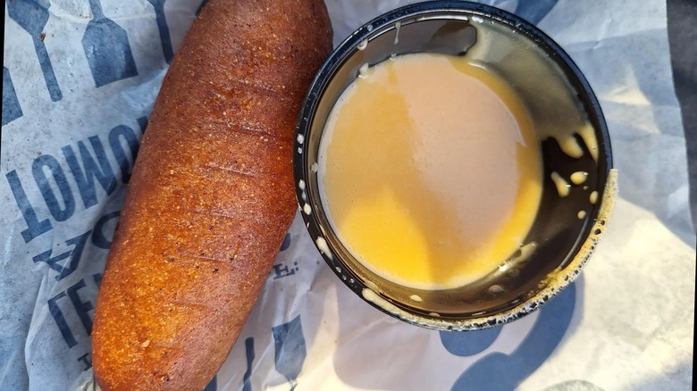 A Culver's corn dog with a side of cheese sauce