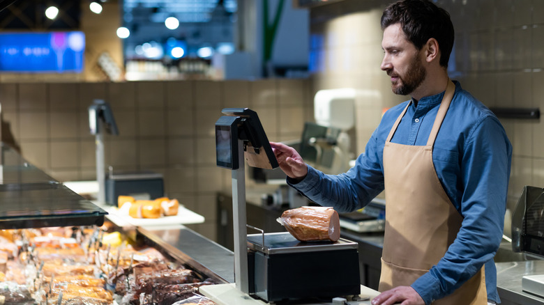 Meat department employee behind counter