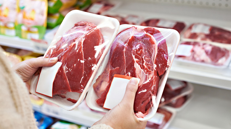 Person holding packages of meat