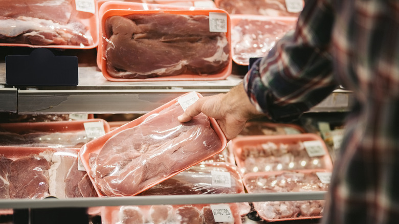 Hand holding package of meat