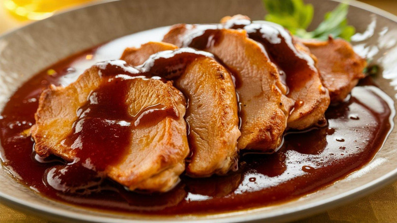 Slices of veal on plate with brown sauce