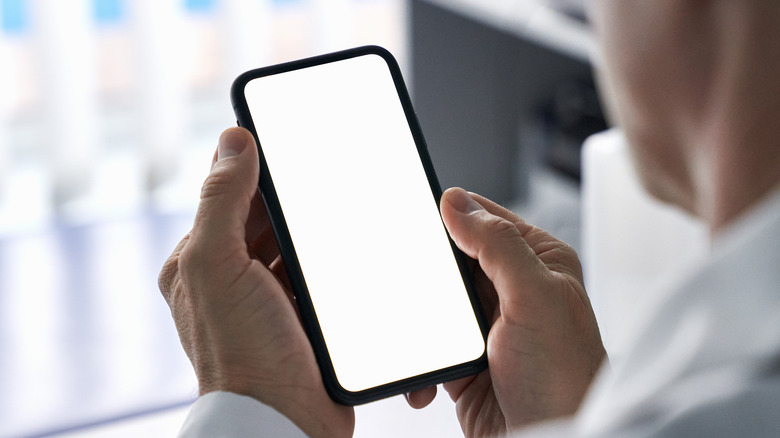 man holding phone with blank screen