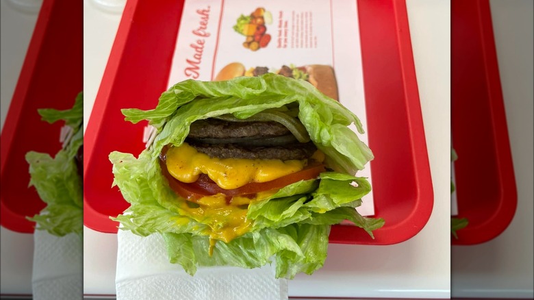 Protein-style In-N-Out burger with lettuce, beef patties, cheese, and tomatoes.