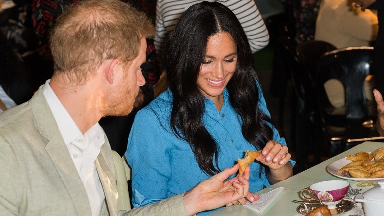 Prince Harry and Meghan Markle sharing a snack