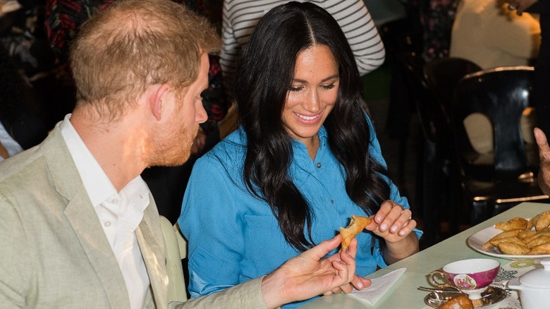 Prince Harry and Meghan Markle sharing a snack