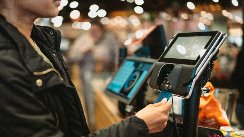 Shopper paying for groceries with card.