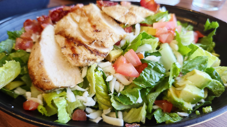 Mixed green salad with chicken on plate