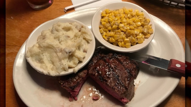 Plate of ribeye steak, corn, and mashed potatoes at Texas Roadhouse.
