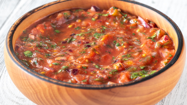 A wooden bowl filled with salsa